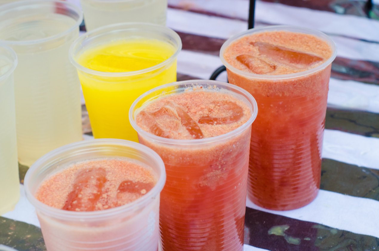 disposable cups with orange juice and strawberry